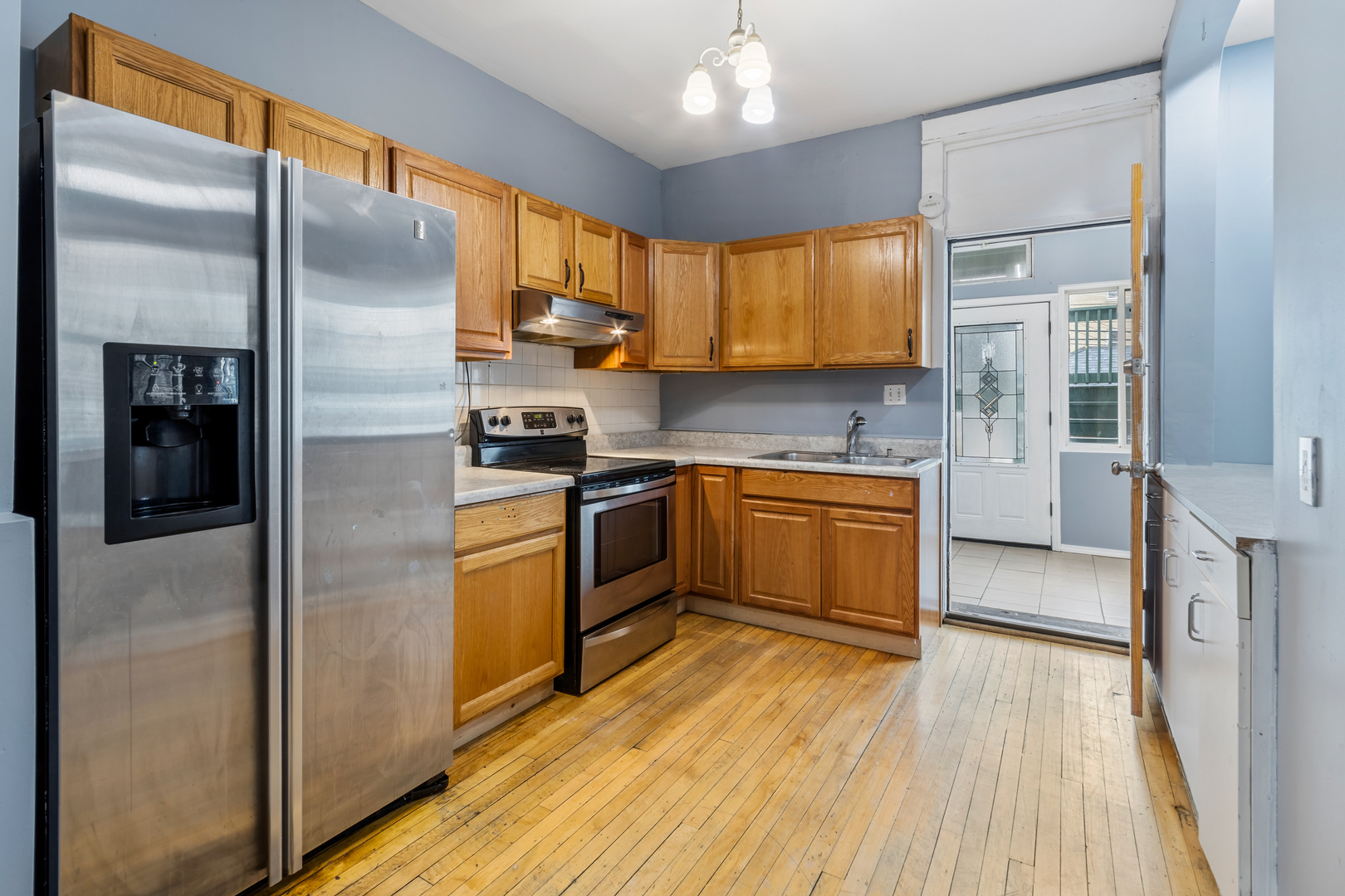 4434 North Drake Avenue, Unit 1 Chicago, IL 60625 - Photo 2 of 11 a kitchen with a refrigerator a sink dishwasher with a stove and wooden floor