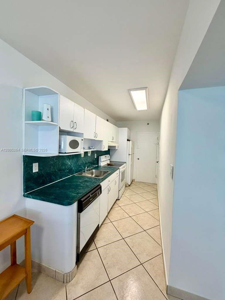100 Lincoln Road, Unit 731 Miami Beach, FL 33139 - Photo 7 of 12 a kitchen with stainless steel appliances granite countertop a stove a sink and a refrigerator