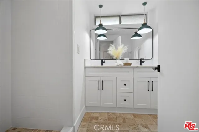 a bathroom with a sink vanity and mirror
