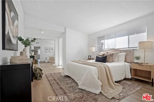 a bedroom with a bed lamps and cabinets