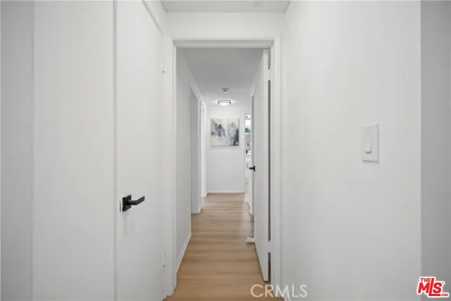 a view of a hallway with a livingroom and a bathroom