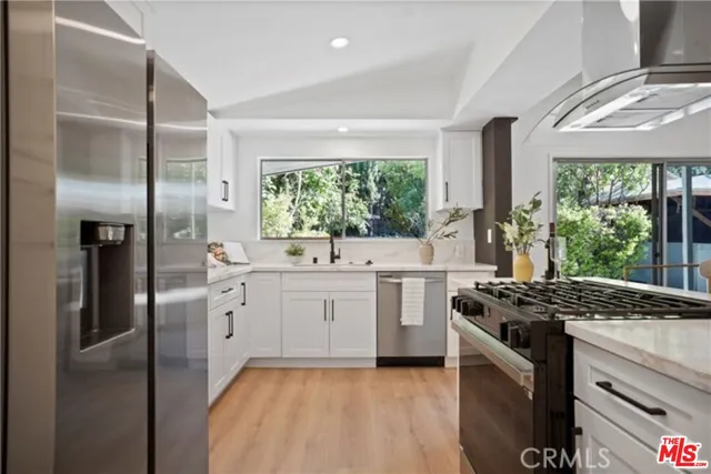 a kitchen with stainless steel appliances granite countertop a stove a sink and a refrigerator
