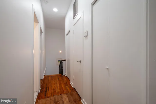 a view of a hallway with a door and stairs