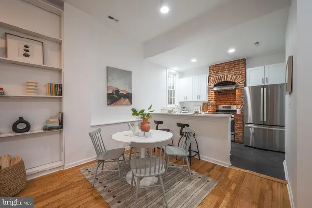 a kitchen with a dining table chairs refrigerator and cabinets