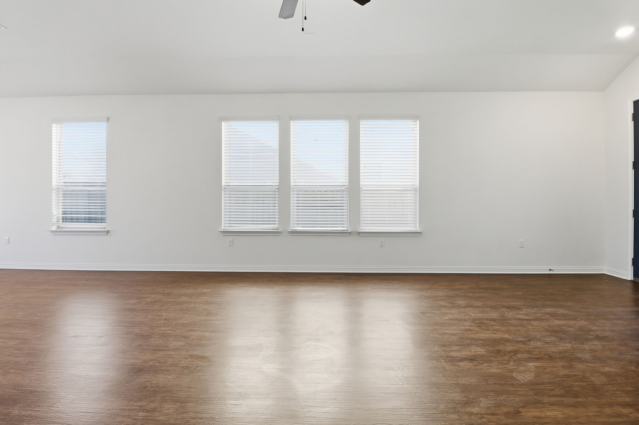5908 Gerard Drive Austin, TX 78744 - Photo 10 of 34 Unfurnished room with dark wood-style flooring, a ceiling fan, healthy amount of natural light, and lofted ceiling