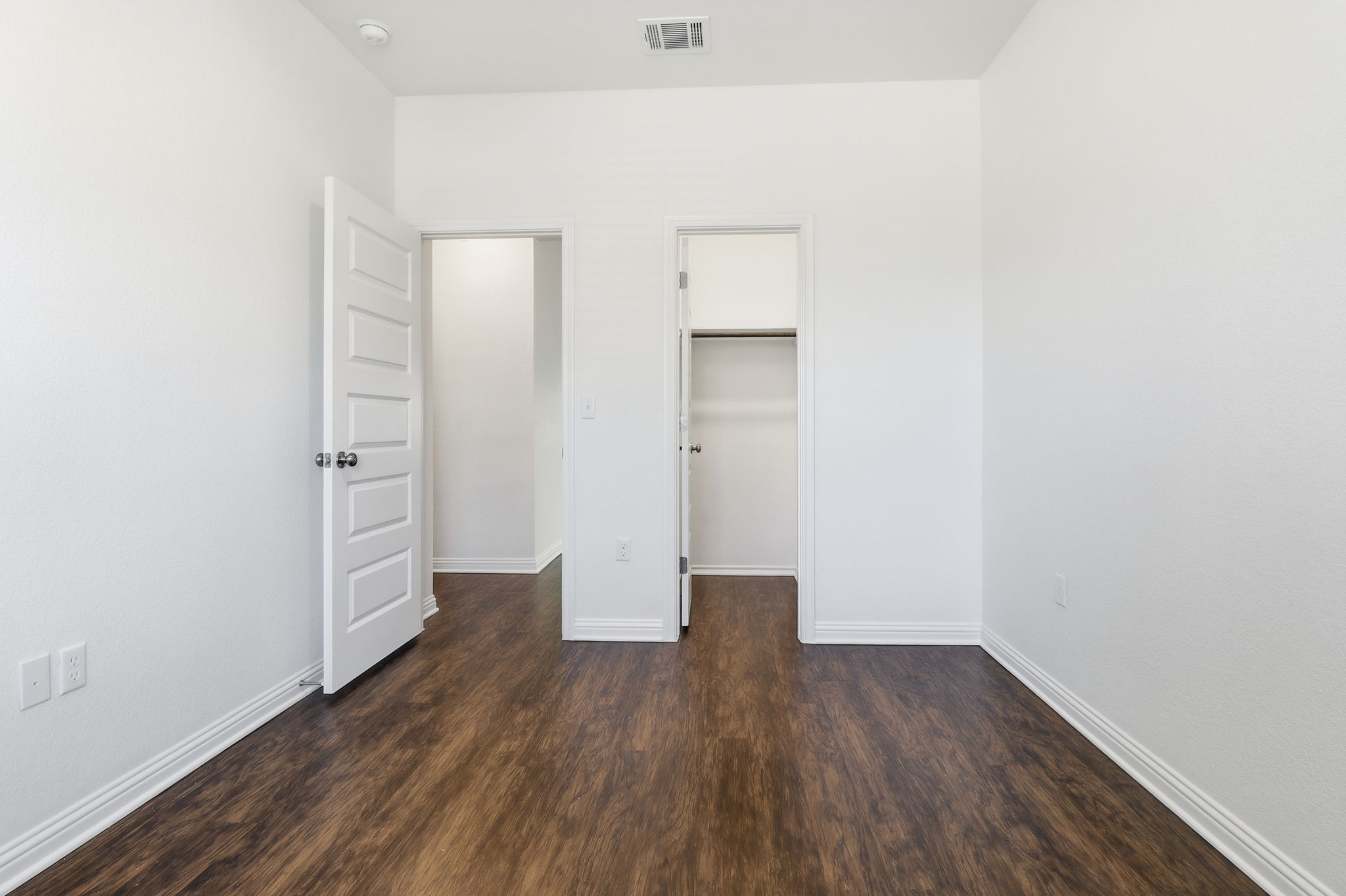 5908 Gerard Drive Austin, TX 78744 - Photo 18 of 34 Unfurnished bedroom featuring a walk in closet and dark wood-style floors