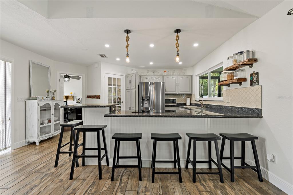808 Rustic Oaks Drive Palm Harbor, FL 34684 - Photo 13 of 55 a kitchen with stainless steel appliances granite countertop table chairs sink and stove top oven