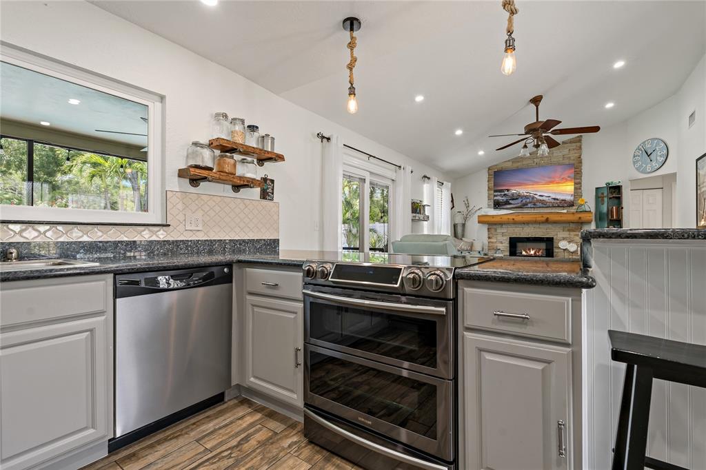 808 Rustic Oaks Drive Palm Harbor, FL 34684 - Photo 14 of 55 a kitchen with stainless steel appliances granite countertop a stove and a sink