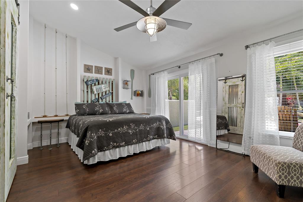 808 Rustic Oaks Drive Palm Harbor, FL 34684 - Photo 22 of 55 a bedroom with a large bed chandelier and a window