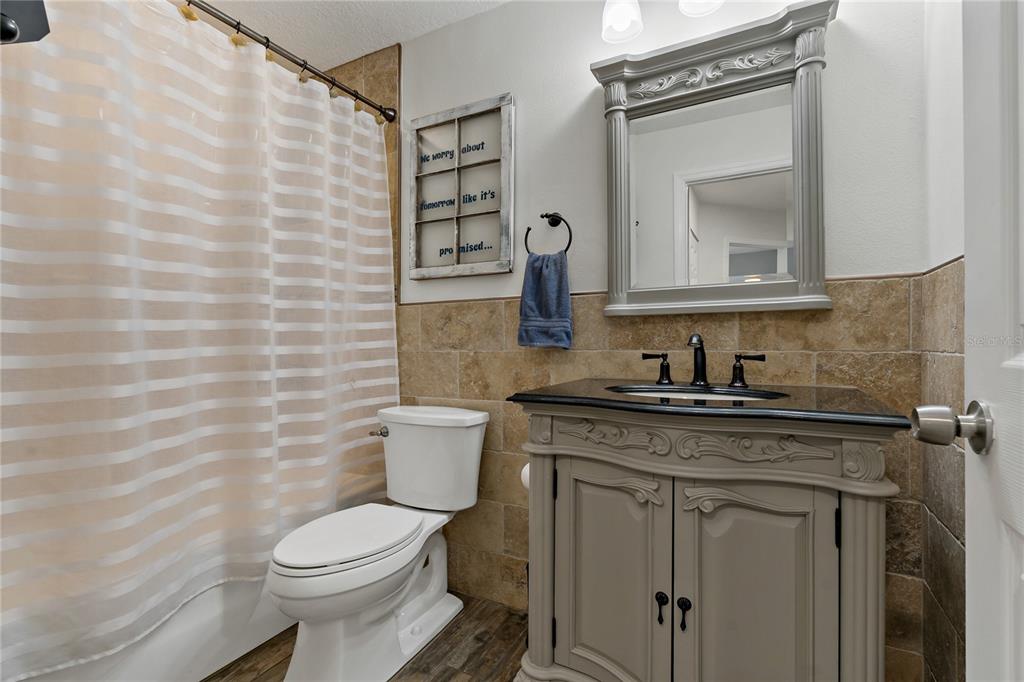 808 Rustic Oaks Drive Palm Harbor, FL 34684 - Photo 33 of 55 a bathroom with a granite countertop toilet sink and mirror