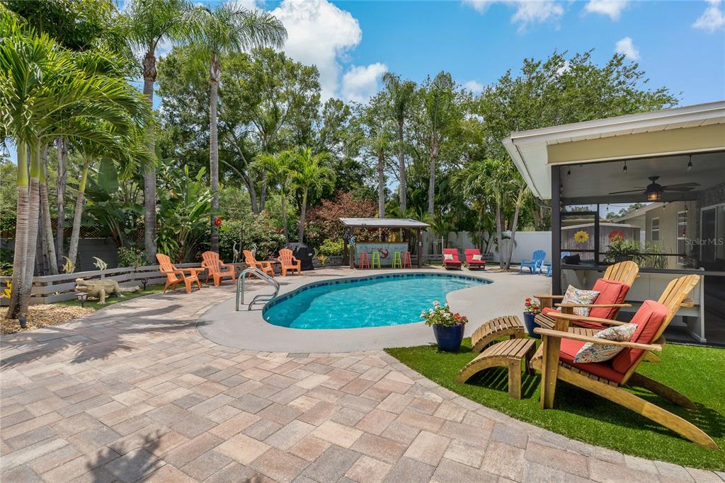 808 Rustic Oaks Drive Palm Harbor, FL 34684 - Photo 40 of 55 a view of a patio with a table and chairs under an umbrella