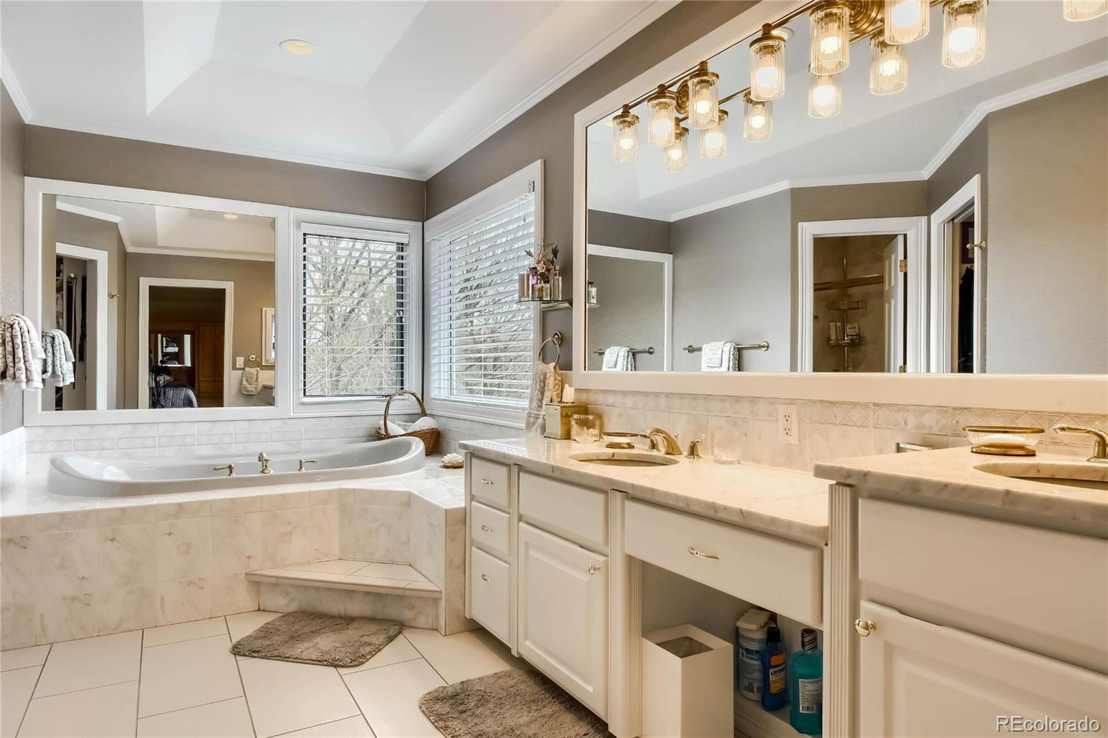 3935 Pierson Street Wheat Ridge, CO 80033 - Photo 16 of 40 a bathroom with a sink a large mirror and a bathtub