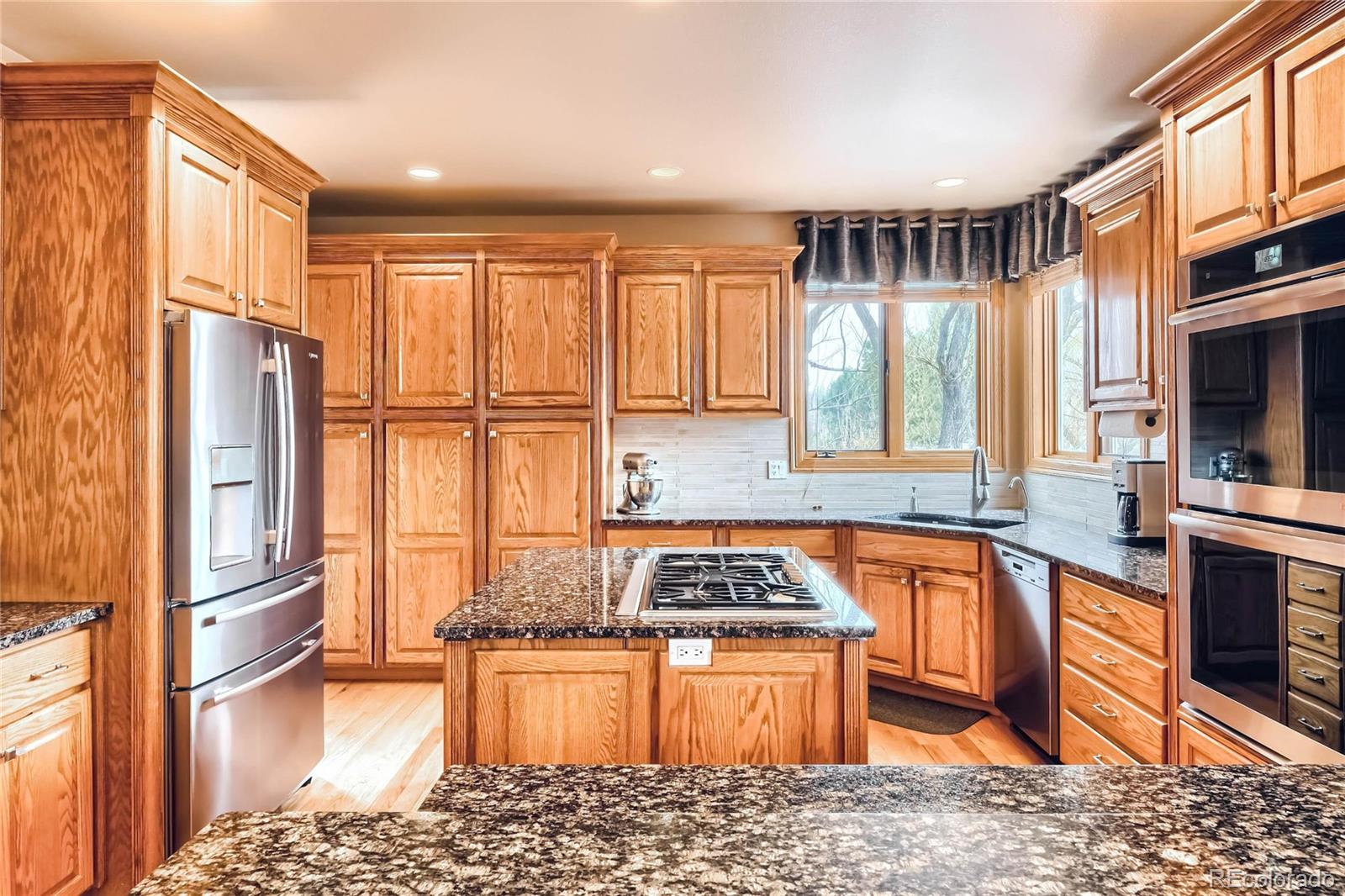 3935 Pierson Street Wheat Ridge, CO 80033 - Photo 9 of 40 a kitchen with stainless steel appliances granite countertop a refrigerator stove top oven and sink