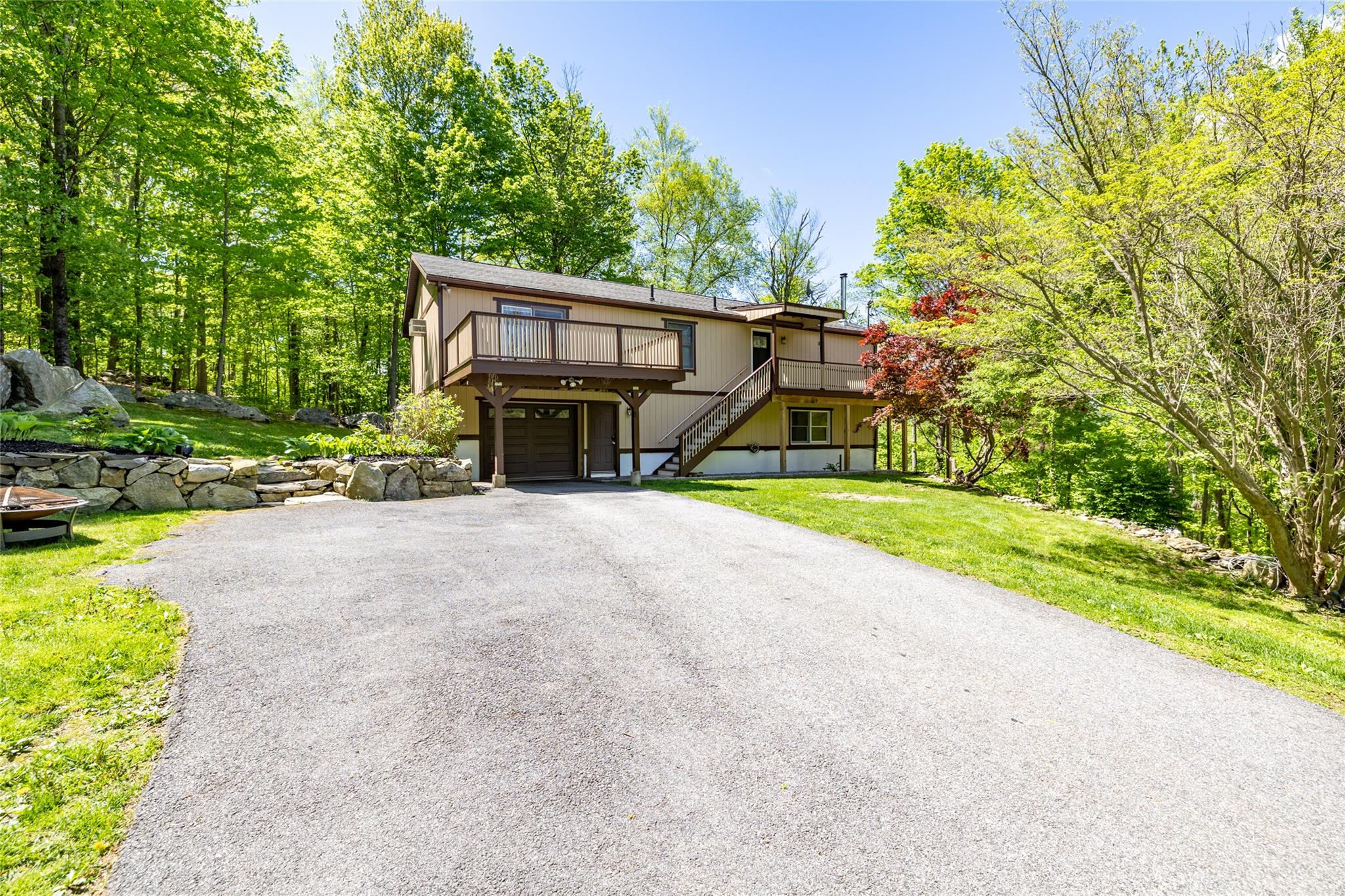 281 McManus Road North Patterson, NY 12563 - Photo 1 of 1 View of front of property with driveway, a wooden deck, stairs, a garage, and a front lawn