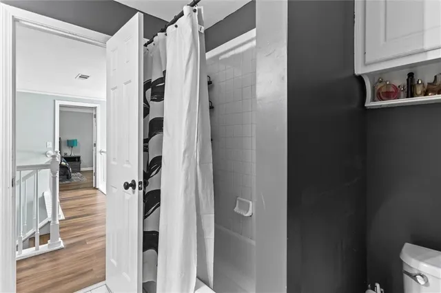 a view of a hallway with wooden floor and closet