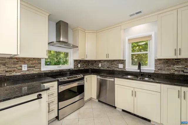 a kitchen with granite countertop white cabinets and a sink