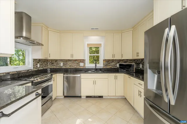 a kitchen with stainless steel appliances granite countertop a stove a sink and a refrigerator
