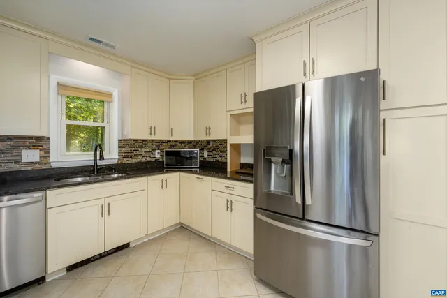 a kitchen with stainless steel appliances granite countertop a refrigerator and a sink