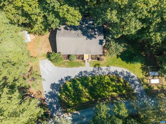 an aerial view of a house with a yard and large trees