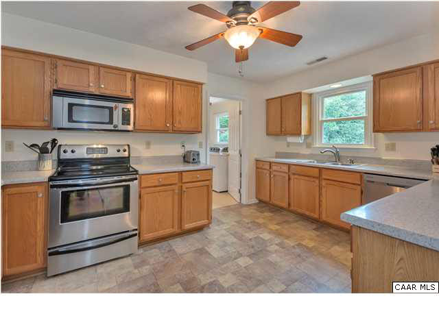 6 Spring Oaks Lane Ruckersville, VA 22968 - Photo 11 of 27 a kitchen with stainless steel appliances granite countertop a sink a stove top oven a refrigerator with grey cabinets