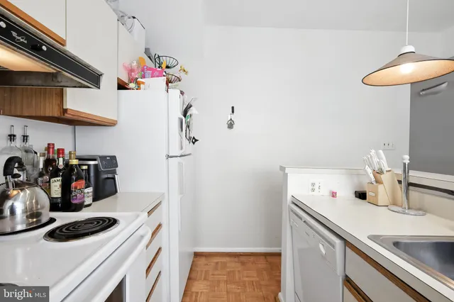 a kitchen that has a sink a stove and cabinets