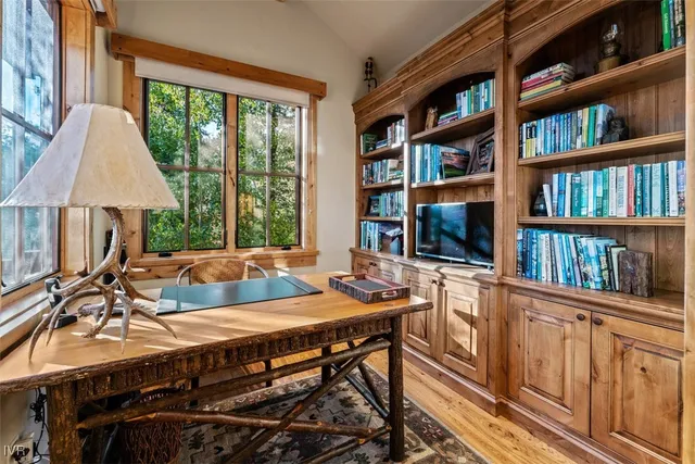 a view of a workspace with furniture and a bookshelf
