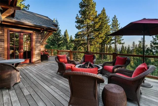 a patio with wooden floor table and chairs