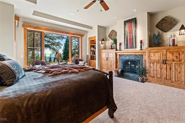 a spacious bedroom with a bed a fireplace and a large window