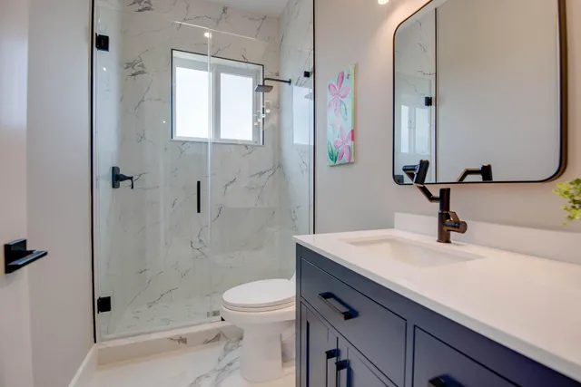a bathroom with a sink a toilet and shower