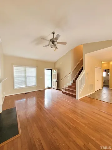a view of an empty room with window and wooden floor