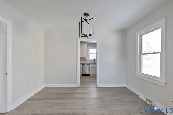 a view of a hallway with wooden floor and windows