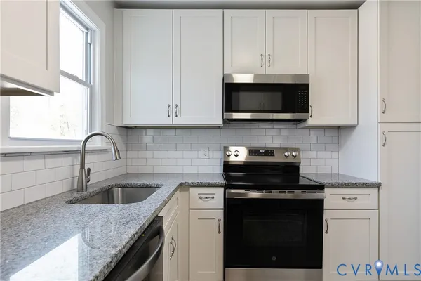 a view of a refrigerator in kitchen and white cabinets