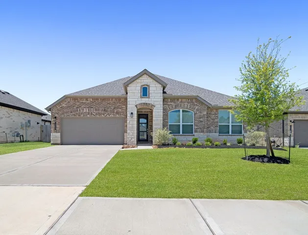 a front view of a house with a garden and trees