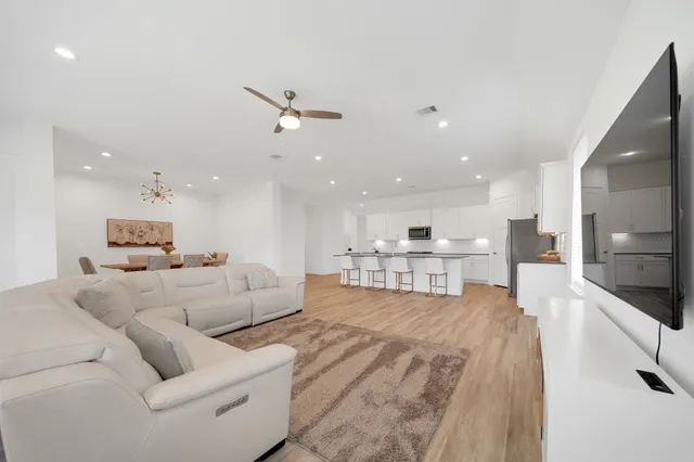 a living room with furniture and a view of kitchen