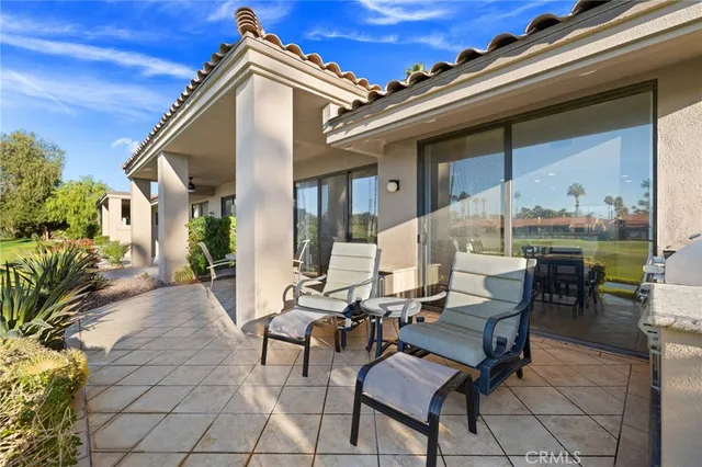 a view of a dinning table and chairs in patio of the house