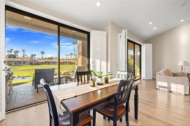 a dining room with furniture a chandelier and wooden floor