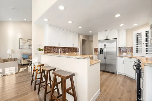 a kitchen with refrigerator and chairs