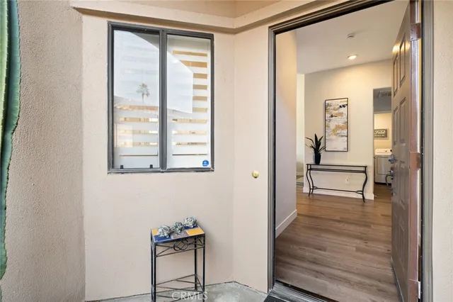 a view of a hallway with wooden floor and a bathroom