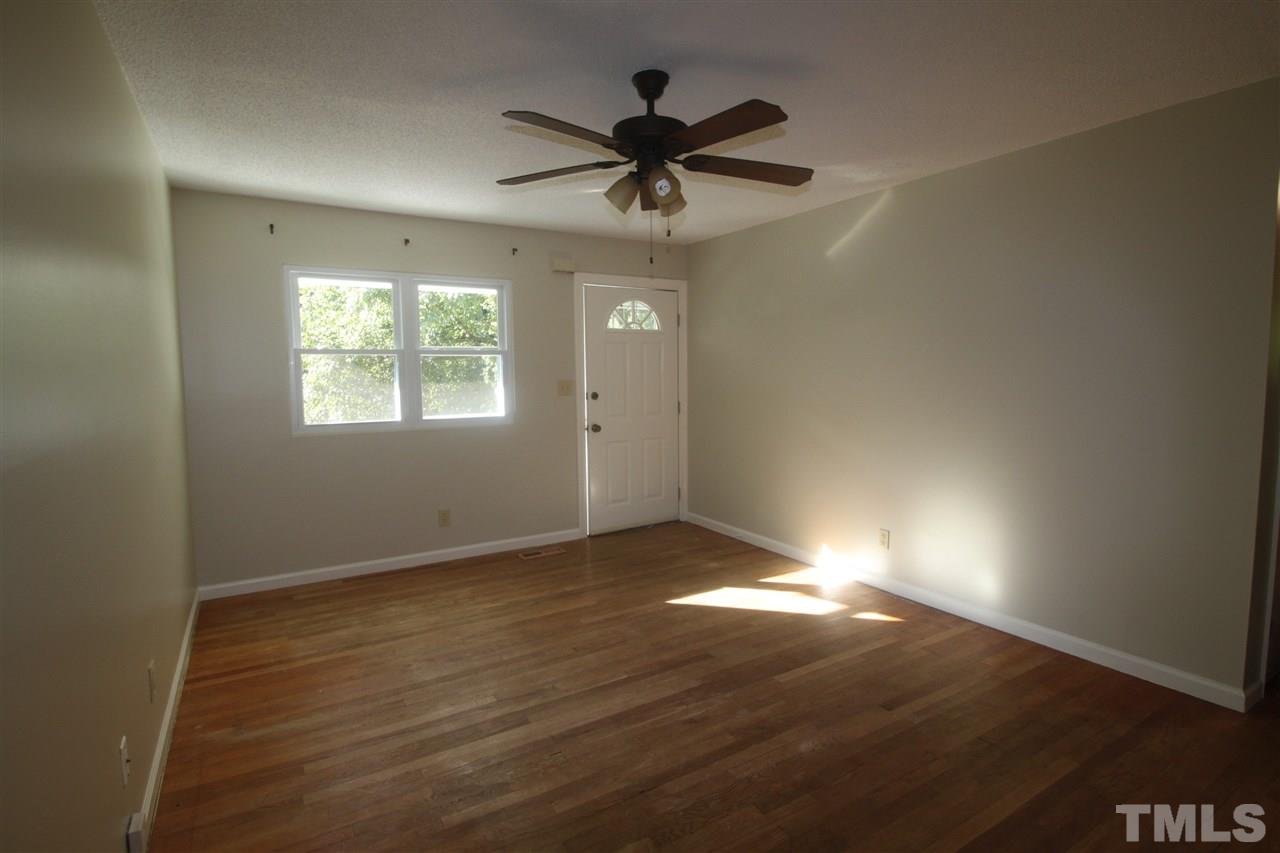 1409 Kelly Road Garner, NC 27529 - Photo 4 of 20 an empty room with wooden floor fan and windows