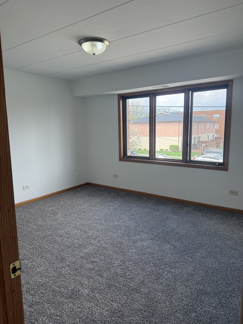 5627 107th Street, Unit 2E Chicago Ridge, IL 60415 - Photo 5 of 9 an empty room with a window