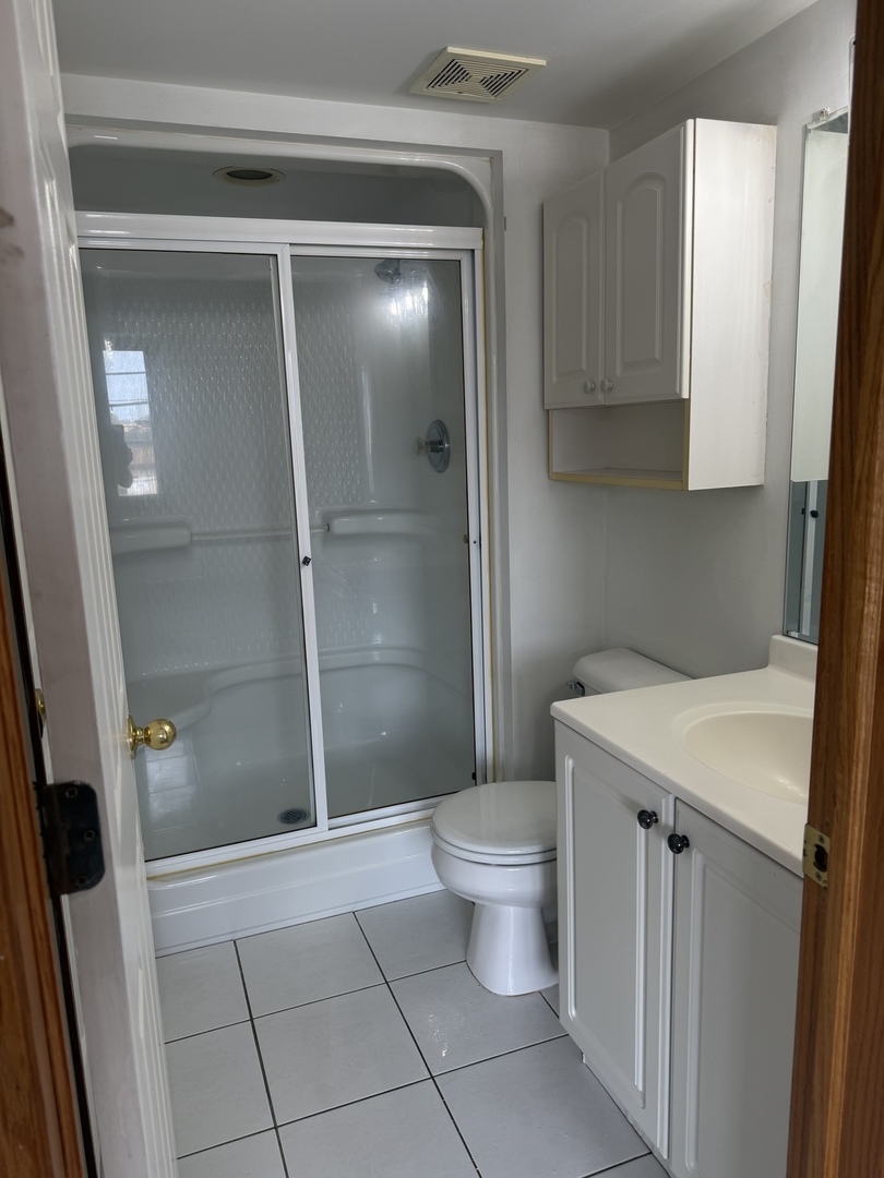 5627 107th Street, Unit 2E Chicago Ridge, IL 60415 - Photo 7 of 9 a bathroom with a shower a toilet and sink