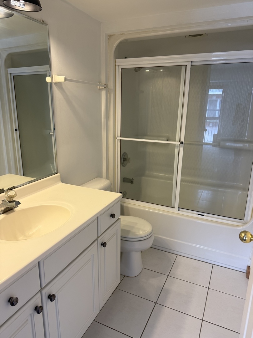5627 107th Street, Unit 2E Chicago Ridge, IL 60415 - Photo 8 of 9 a bathroom with a granite countertop sink toilet and shower