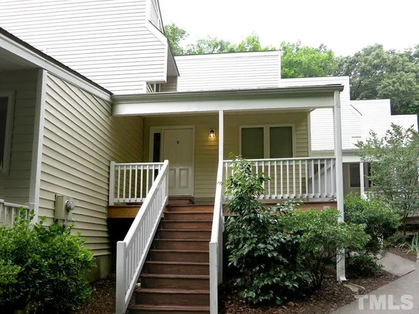 a view of a house with large windows and flower plants