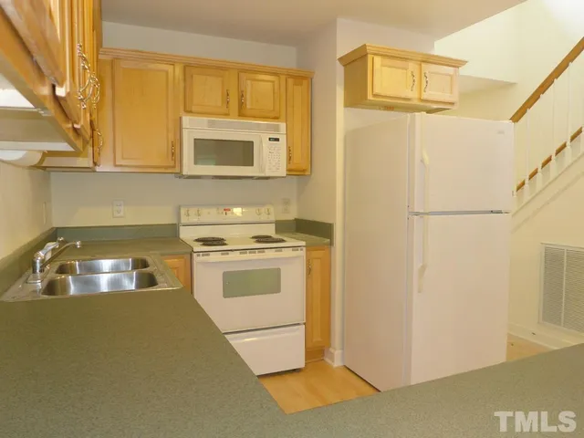 a kitchen with a stove cabinets and a refrigerator