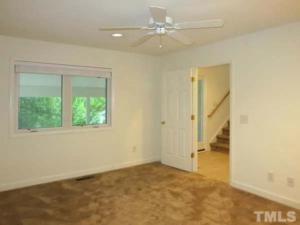 an empty room with a ceiling fan and a window