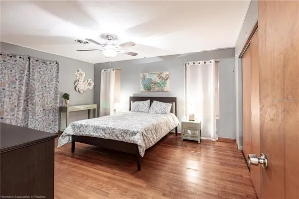 a bedroom with a bed and wooden floor