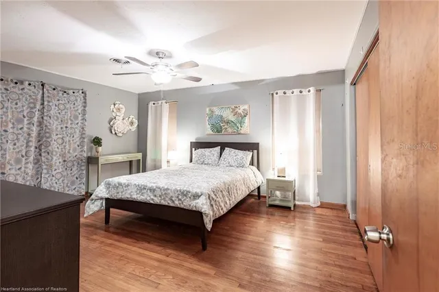 a bedroom with a bed and wooden floor