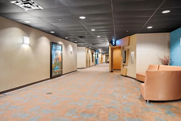 a open kitchen with stainless steel appliances kitchen island granite countertop a table chairs and a refrigerator