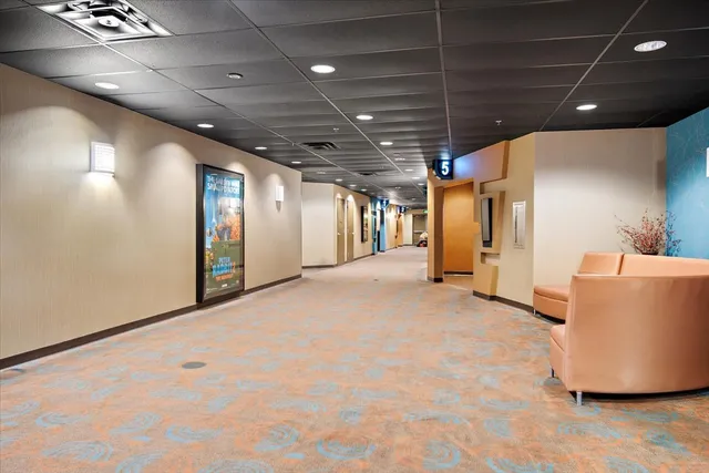 a open kitchen with stainless steel appliances kitchen island granite countertop a table chairs and a refrigerator