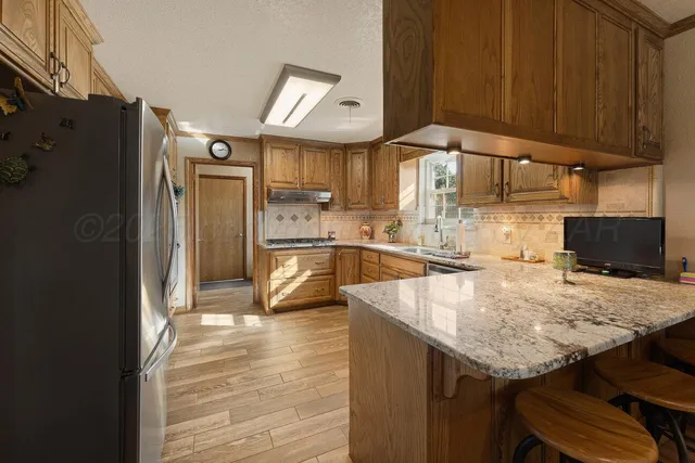 a kitchen with a sink stove top oven and cabinets